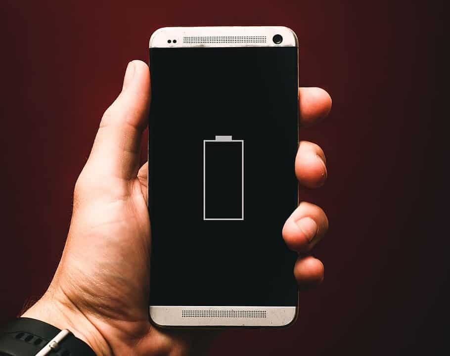 person holding a phone showing low battery
